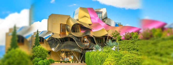 Trip Niederlande Reisetipps - Marqués de Riscal Design Hotel, Bilbao, Elciego, Spanien. Fantastisch galaktisch, unverkennbar ein Werk von Frank O. Gehry. Inmitten idyllischer Weinberge in der Rioja Region des Baskenlandes, bezaubert das schimmernde Bauobjekt mit einer Struktur bunter, edel glänzender verflochtener Metallbänder. Glanz im Baskenland - Es muss etwas ganz Besonderes sein. Emotional, zukunftsweisend, einzigartig. Denn in dieser Region, etwa 133 km südlich von Bilbao, sind Weingüter normalerweise nicht für die Öffentlichkeit zugänglich.